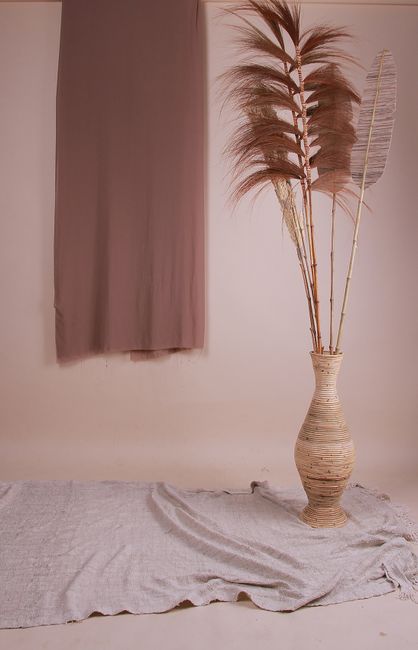 Elegant minimalist decor featuring pampas grass in a wicker vase against a neutral backdrop.