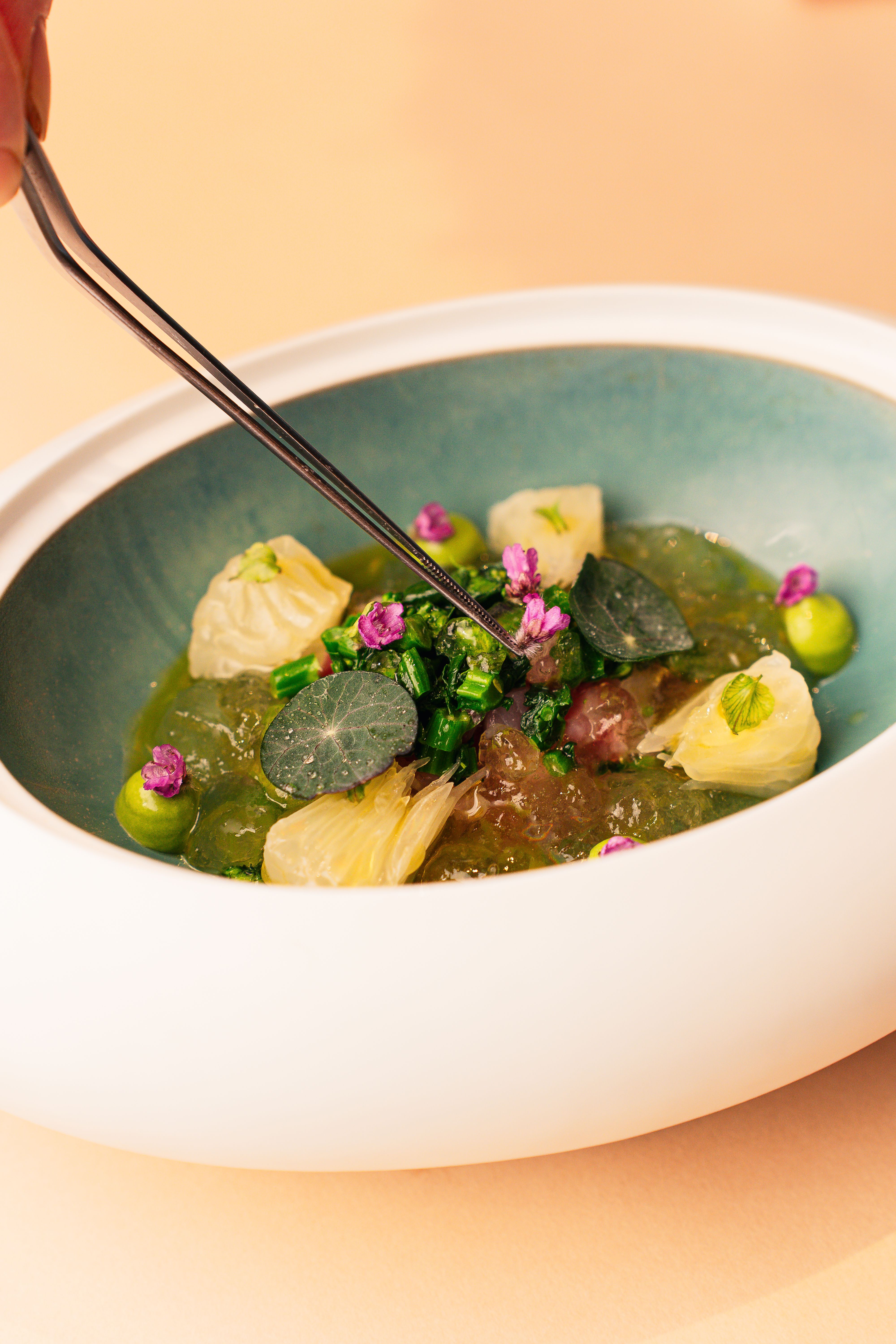A gourmet dessert dish with vibrant garnishes in a fine dining setting in Tokyo, Japan.
