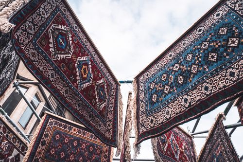 Free Traditional Azerbaijani rugs displayed outdoors, showcasing intricate designs and vibrant colors. Stock Photo