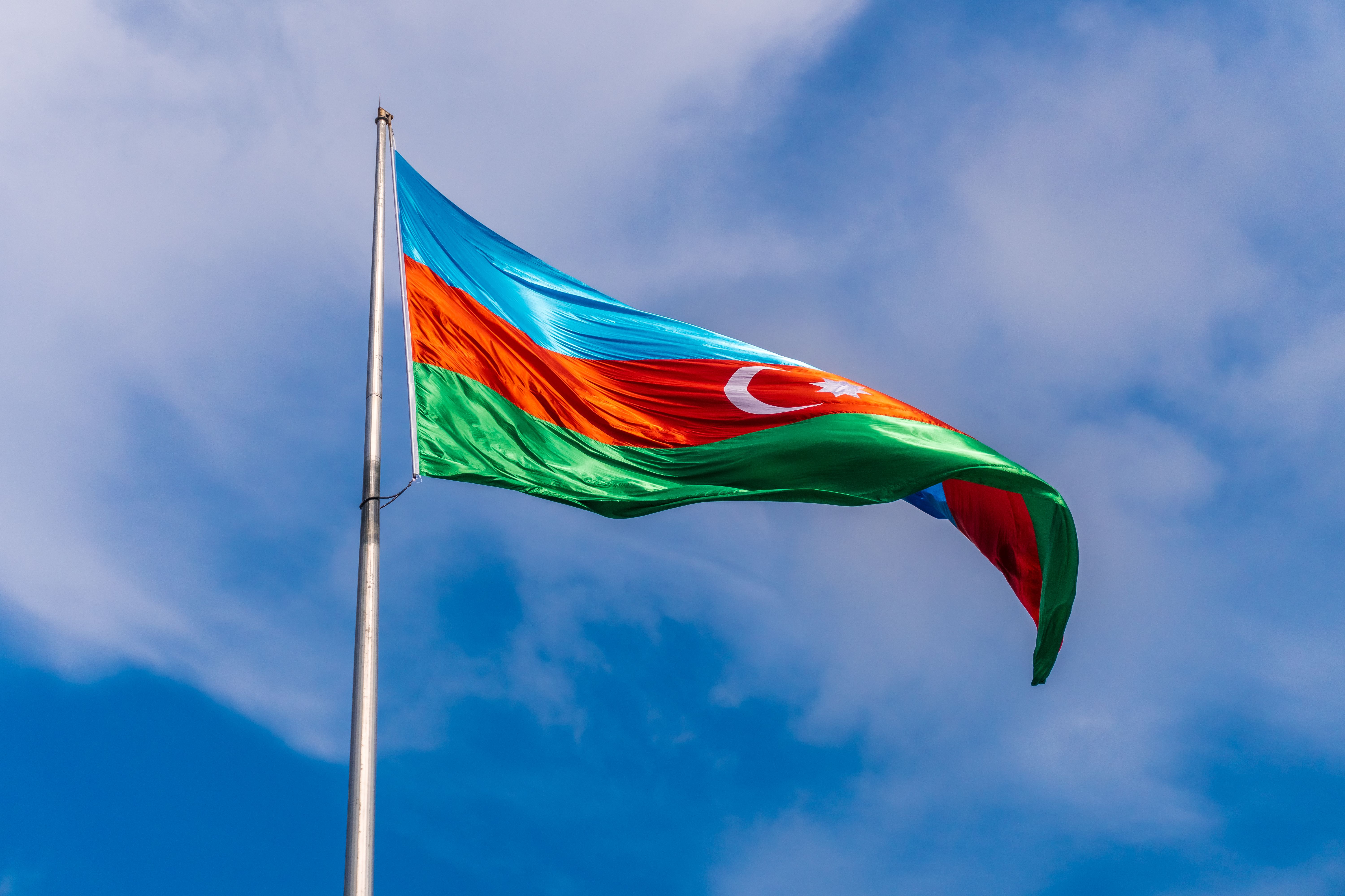 Gratuit Le drapeau national azerbaïdjanais flotte fièrement sur un ciel bleu éclatant, symbolisant la fierté nationale. Photos