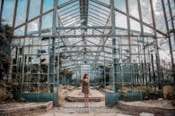 一位身材苗条的匿名女士站在干燥地形上的大半身附近，她移开目光，破坏了对称的建筑；砖块平台上方是天空，白天有云