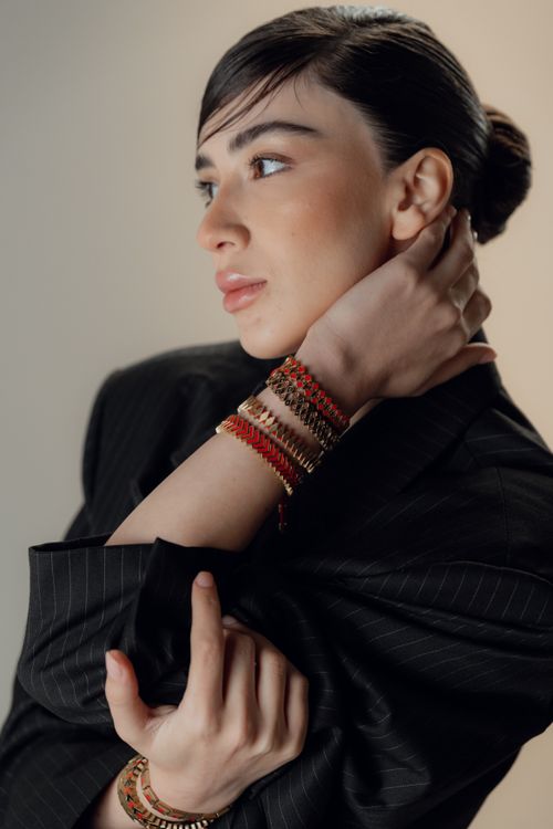 Free Stylish portrait of a woman in a black suit and colorful beaded bracelets, exuding modern elegance. Stock Photo