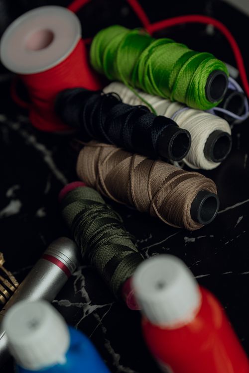Free A variety of colorful sewing threads displayed on a marble surface, perfect for crafting and sewing projects. Stock Photo