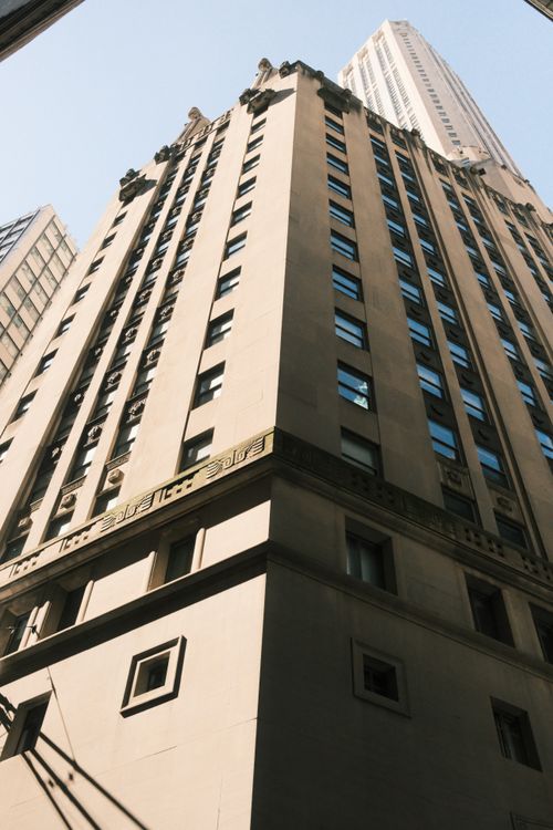 Free Perspective view of a New York skyscraper against a clear blue sky, highlighting urban architecture. Stock Photo