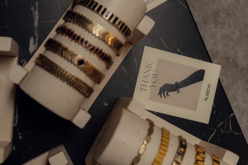 Free Elegant gold and black bracelets displayed on stands with a thank you card, perfect for fashion and retail themes. Stock Photo