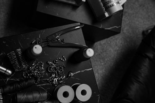 Free Monochromatic image of various tools and supplies on a dark surface, creating an industrial vibe. Stock Photo