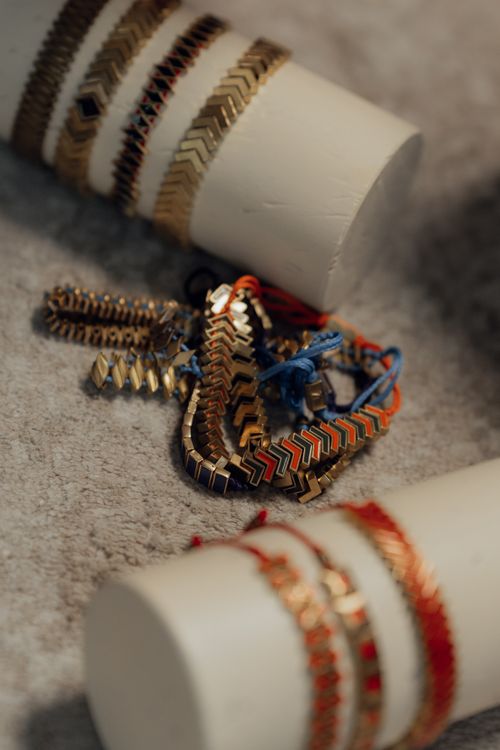 Free Close-up of various gold and colorful bracelets on display, ideal for fashion and jewelry themes. Stock Photo