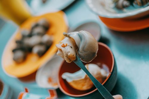 Free Delicious prepared snails in a bowl with fork, perfect for culinary themes and restaurant promotions. Stock Photo