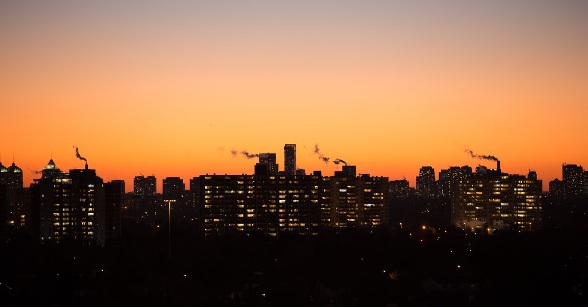 A Toronto street lined with condo buildings at dusk, where a broker checks real fees and rents before an offer