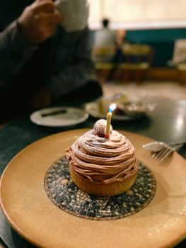 Delicious tart with a candle, served in a cozy Ankara cafe setting.