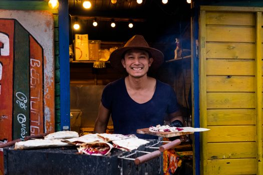 A cheerful street food vendor at an outdoor market in Berlin, Germany, serving traditional culinary delights.