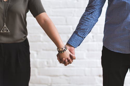 Photo of Man and Woman Holding Hands