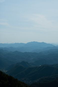 Scenic aerial view of layered mountain ranges under a clear sky.