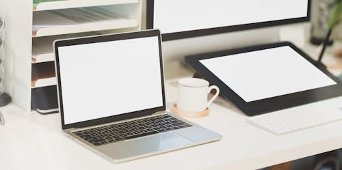 Macbook Pro Beside White Ceramic Mug on White Table