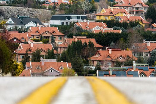 A scenic view of suburban houses with red tile roofs nestled among trees in Ankara, Turkey.