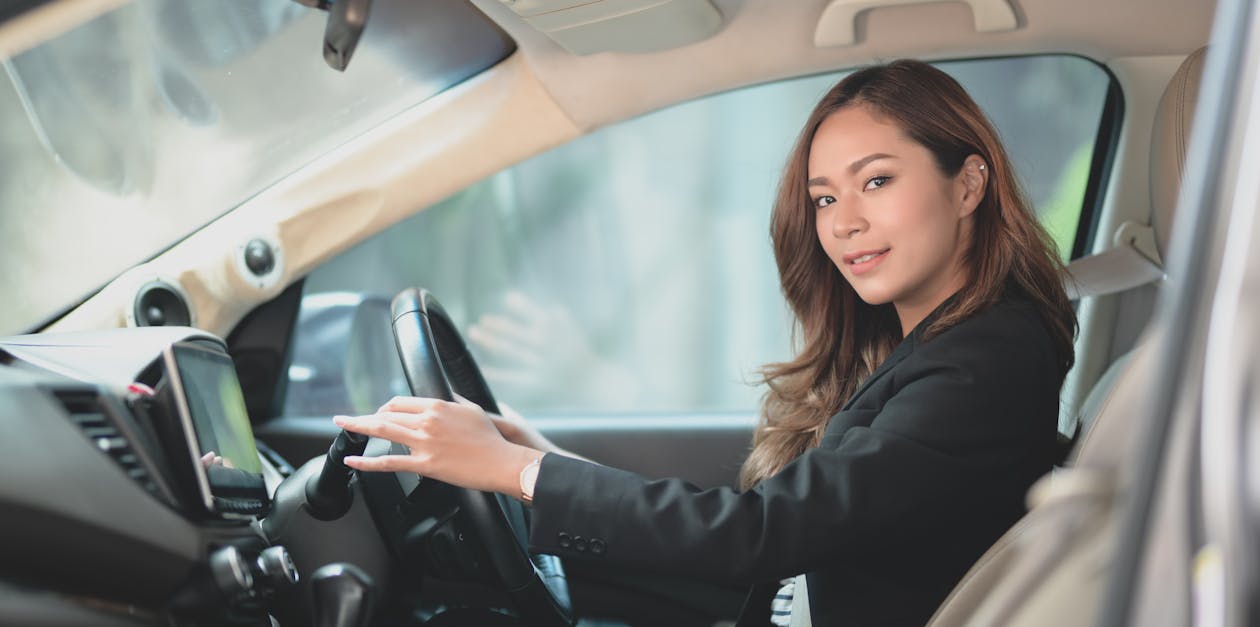 Woman in Black Blazer Driving a Vehicle