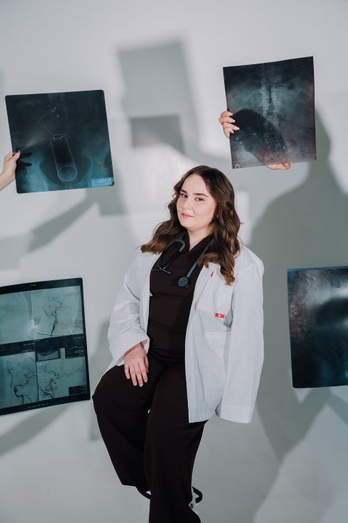 Free Female doctor in a lab coat examining medical X-rays with focus and concentration. Stock Photo