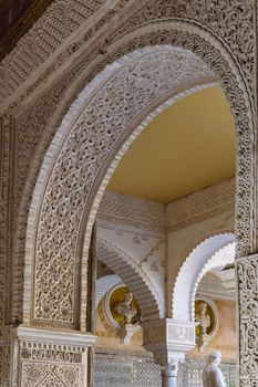 Detailed Moorish arch in the Royal Alcazar of Seville, showcasing stunning Islamic architecture.