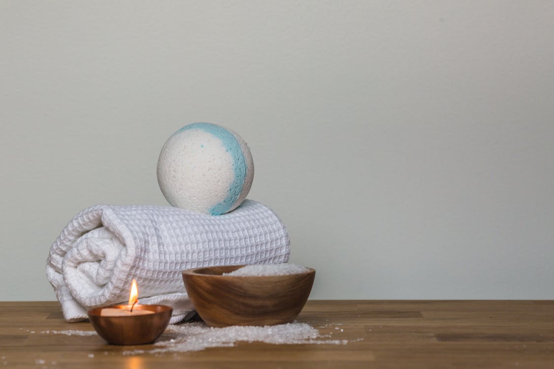 Free Photo of Towel and Bath Bomb Near Candle Stock Photo