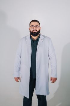 Portrait of a confident male doctor in a white lab coat against a neutral background.