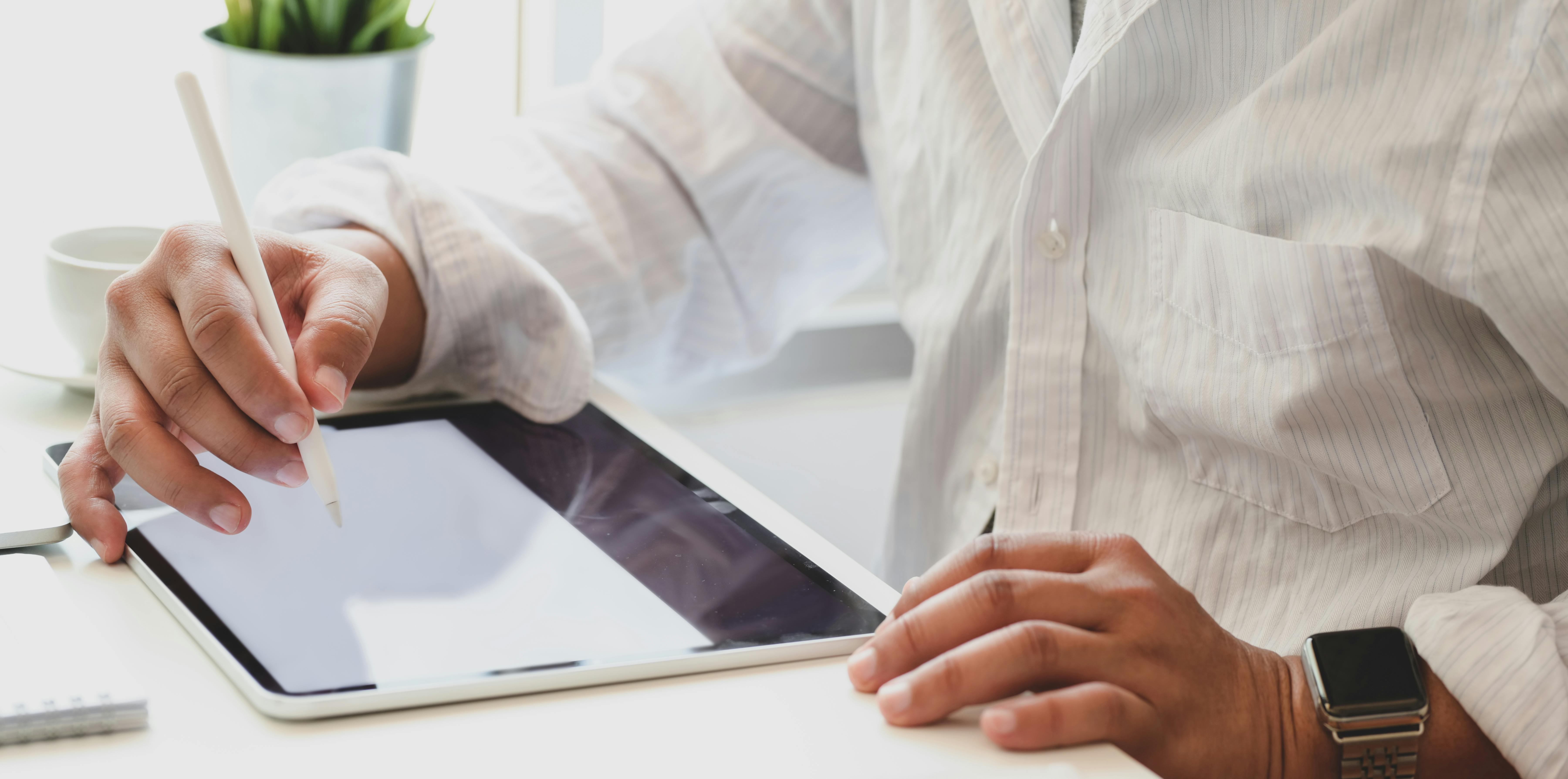 Person in White Long Sleeve Shirt Using  Tablet Computer