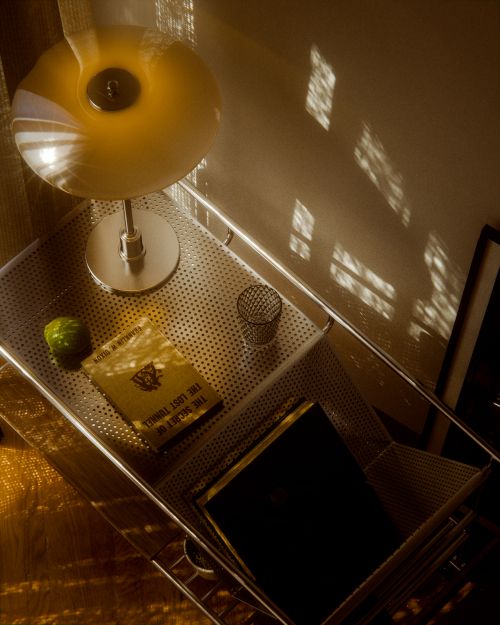Free Warm-toned room with lamp, books, and natural light creating a cozy atmosphere. Stock Photo
