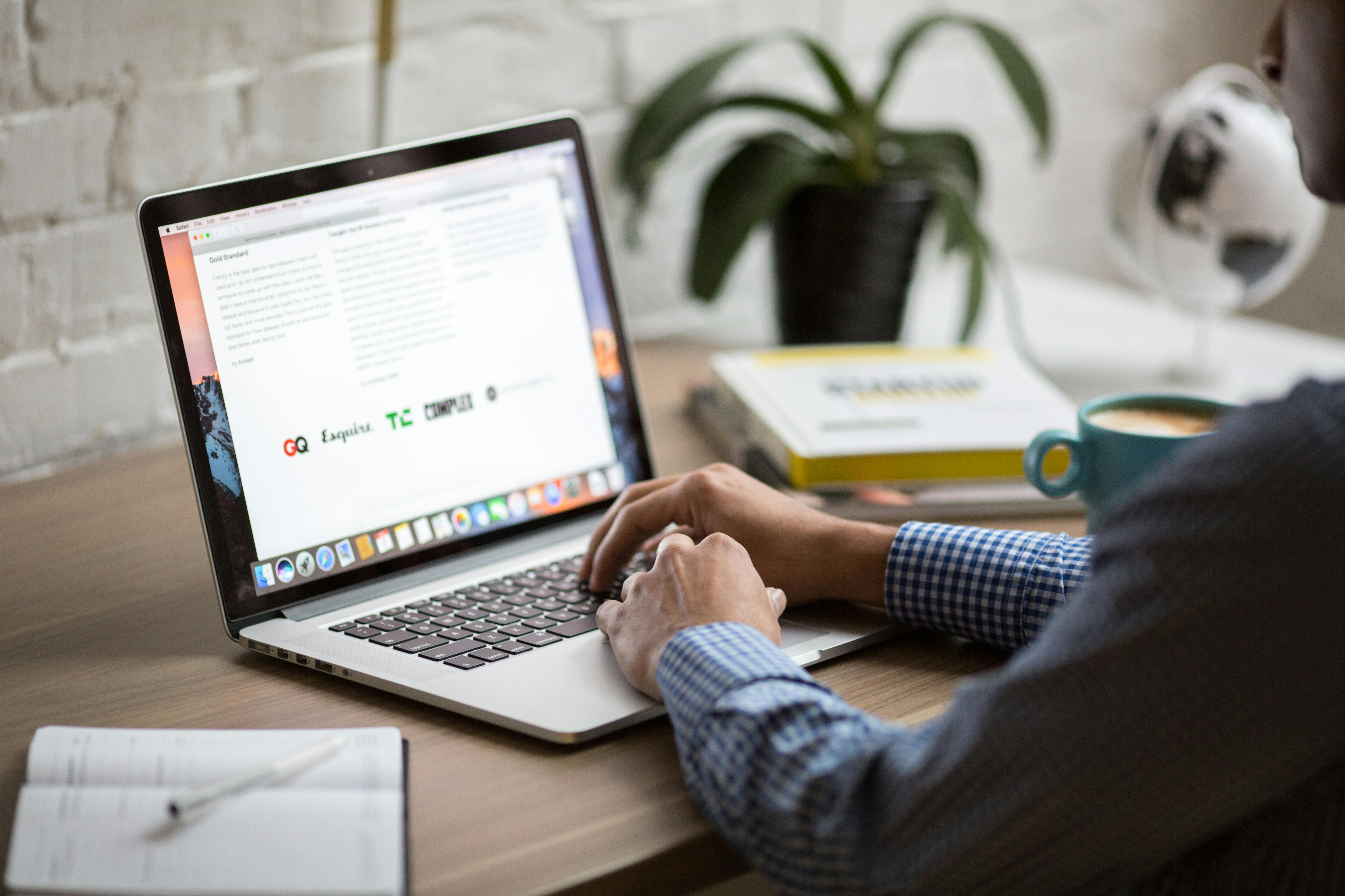 A man writing on his laptop at desk. | Photo: Pexels