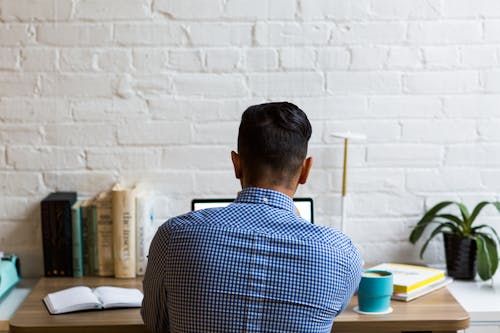 Person Sitting Beside Brown Wooden Table