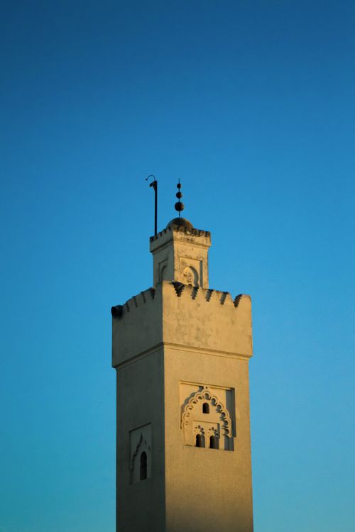 Free A striking architectural minaret in Fes, Morocco, stands tall against a vibrant blue sky. Stock Photo