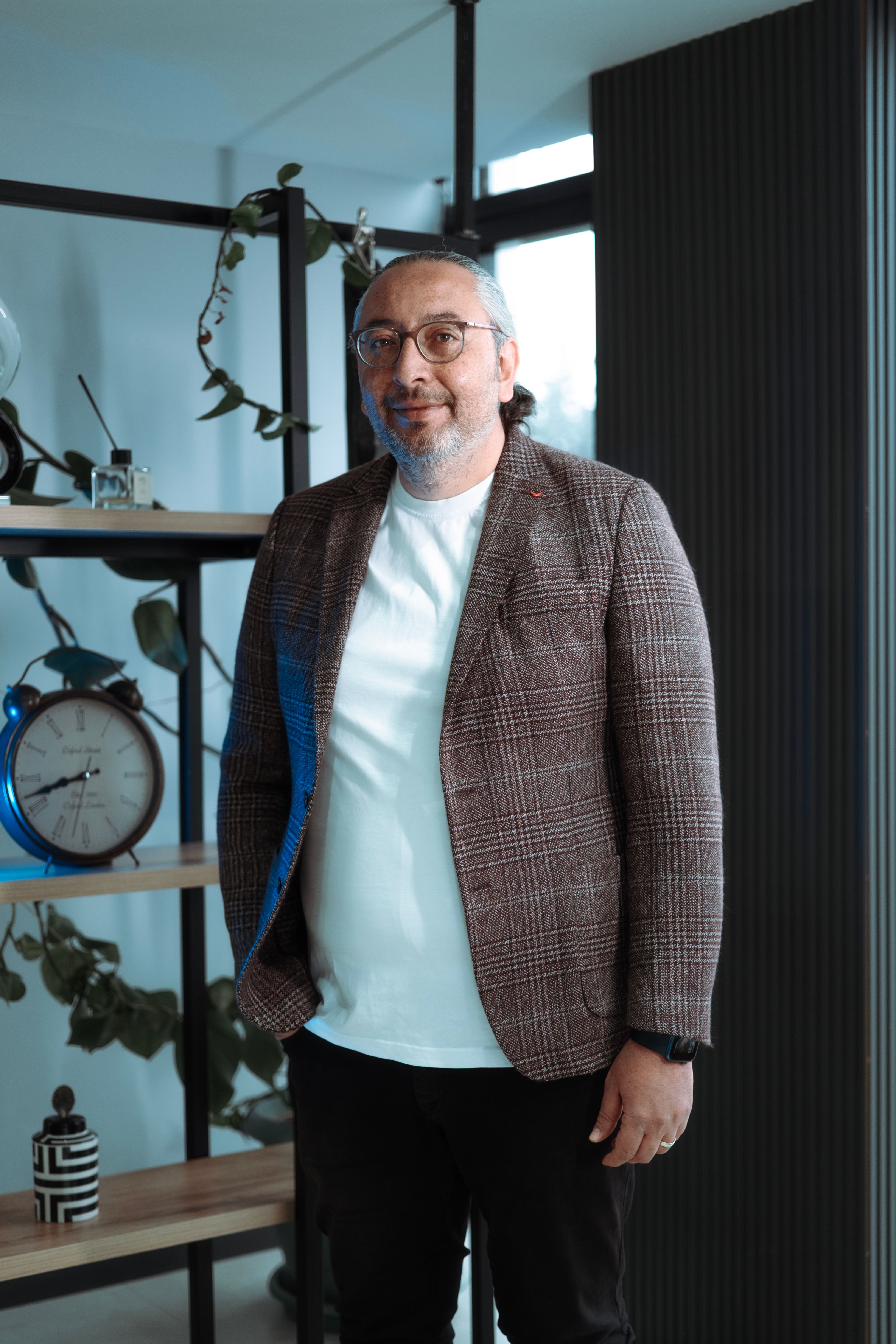 Businessman in a casual office setting with plants and decor.
