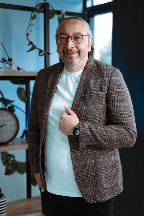 Free Portrait of an adult man in a modern office with greenery and decor, exuding confidence. Stock Photo