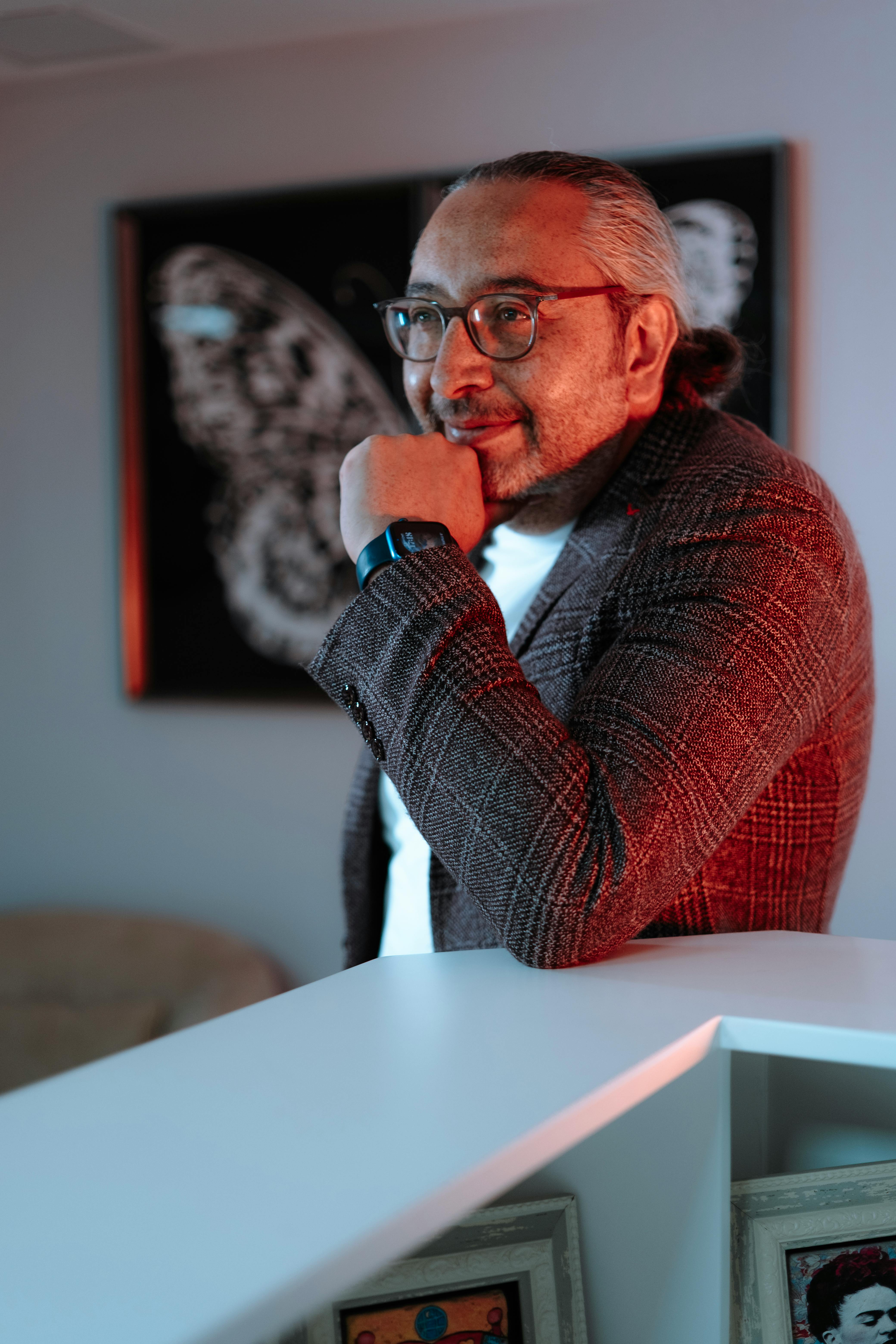 Thoughtful man in stylish outfit standing in a contemporary office with artistic decor.
