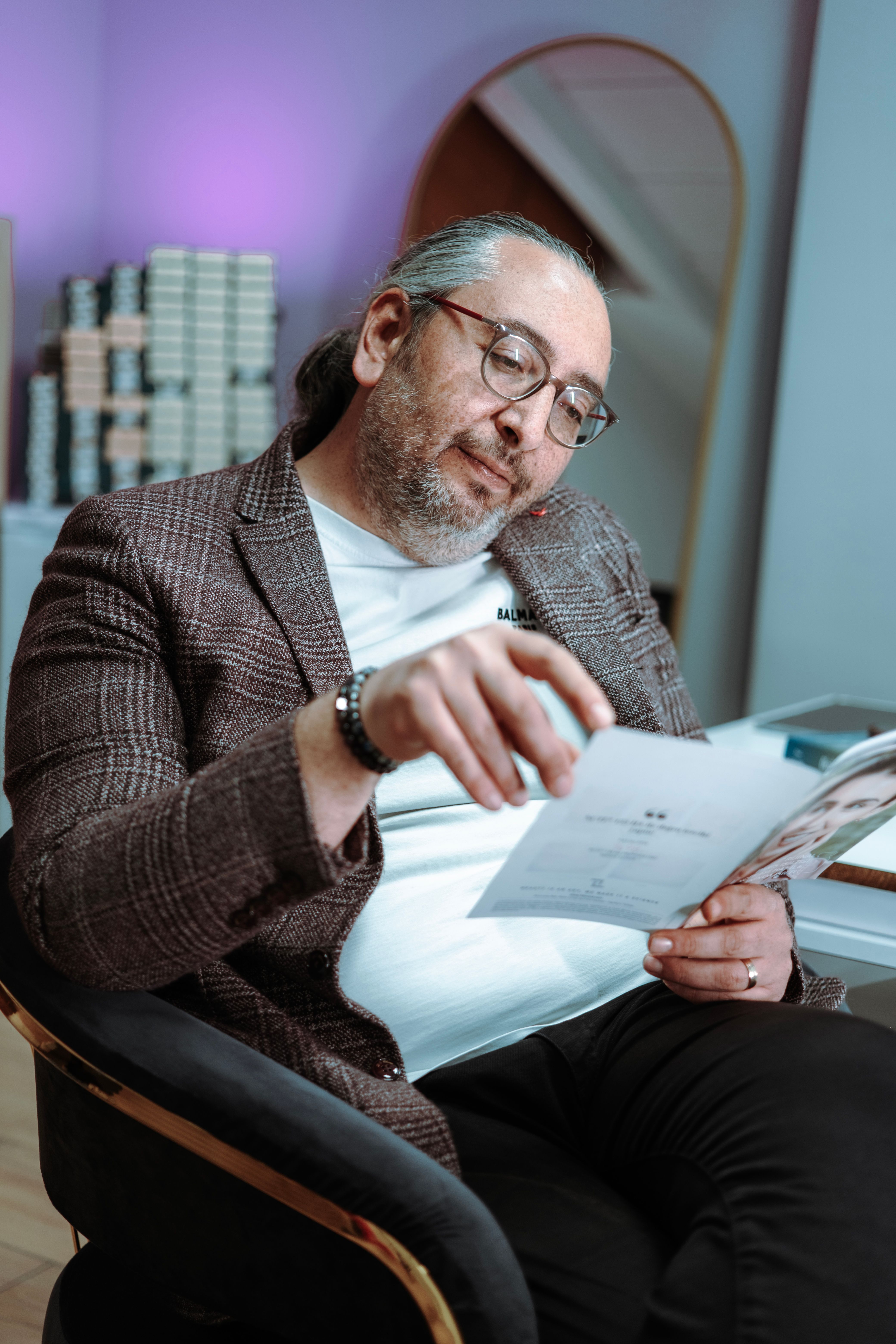 Mature businessman reading a document in a modern office, radiating confidence and professionalism.