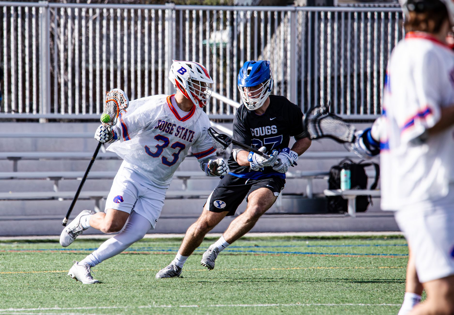 Dynamic action captured during a university lacrosse game in Provo, featuring two players competing.
