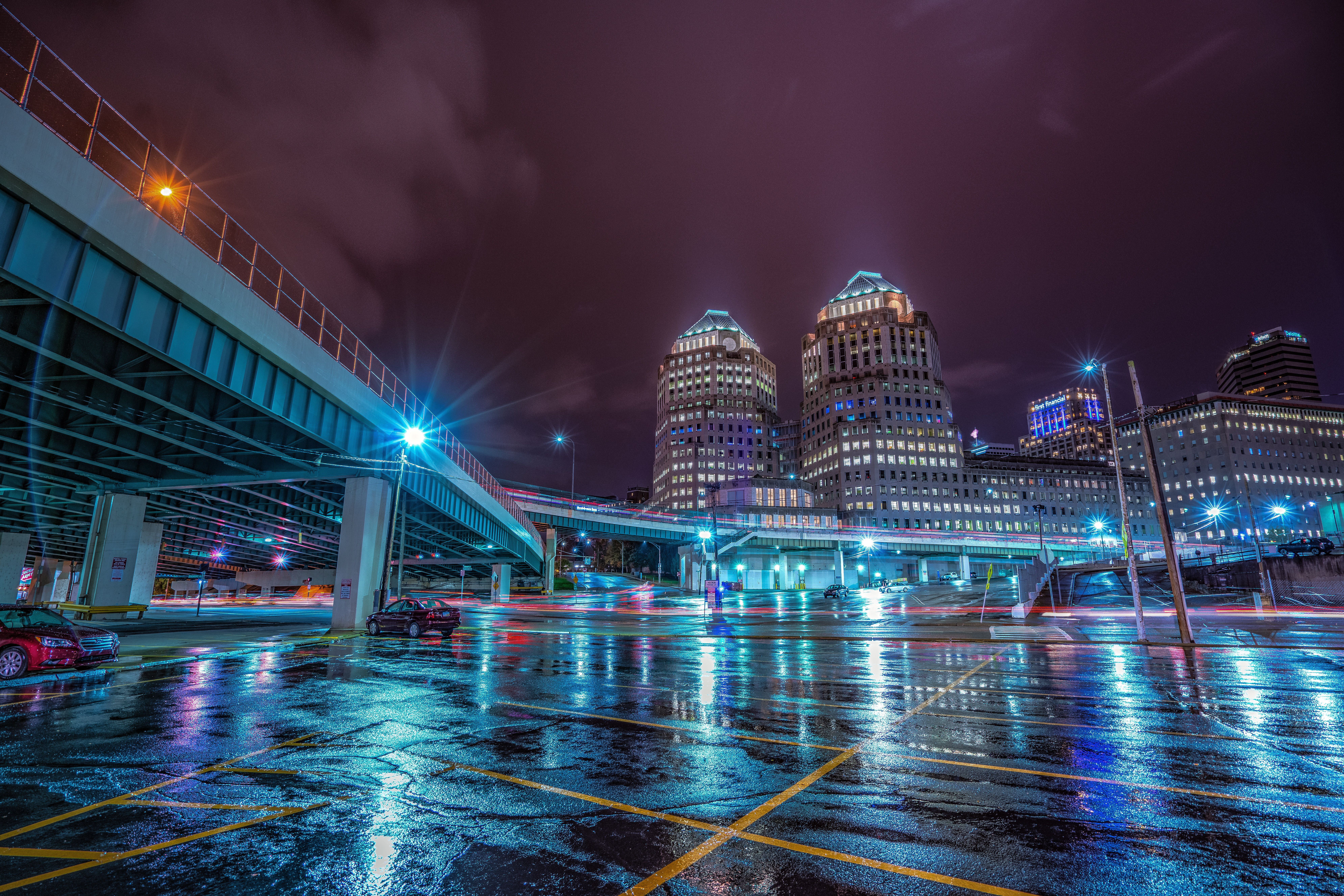 Long exposure of Cincinnati skyline reflecting on wet streets at night.