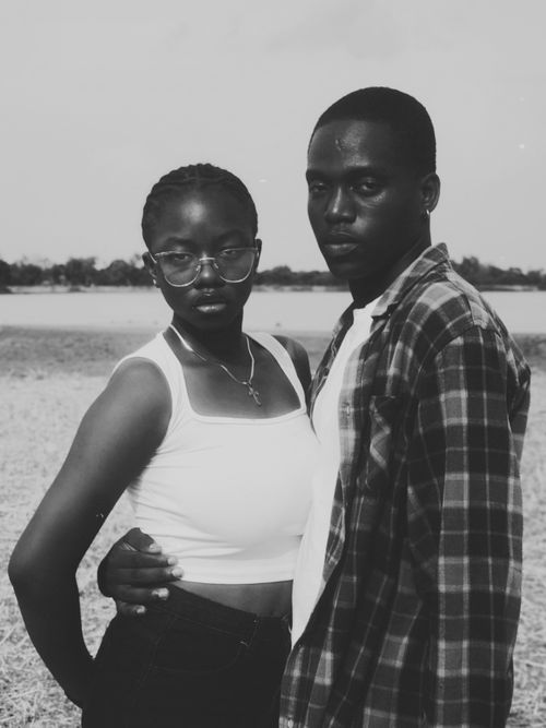 Free Captivating black and white portrait of a couple standing outdoors with serene backdrop. Stock Photo