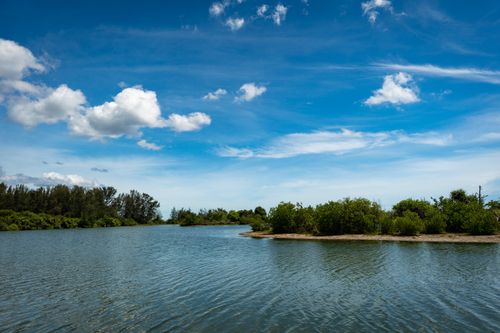 Free Scenic view of Batticaloa Lagoon in Sri Lanka with lush greenery under a vibrant blue sky. Stock Photo