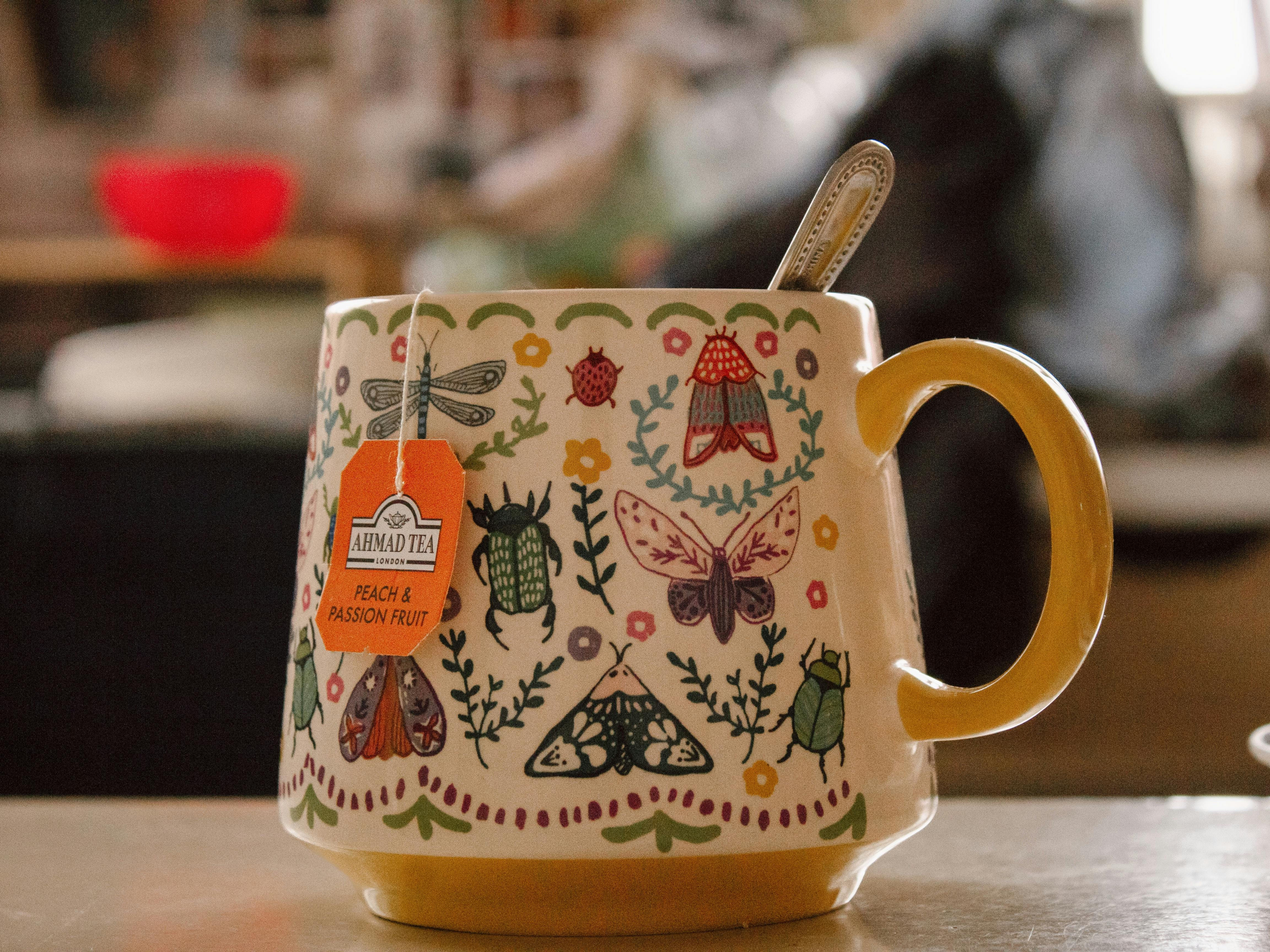 Cozy indoor scene featuring a bug-themed mug with a tea bag label.