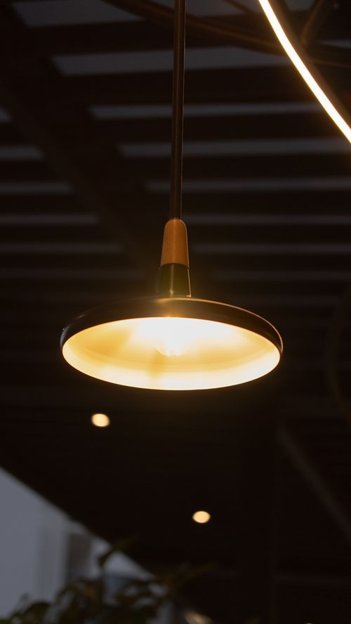 Free Warmly lit pendant lamp hanging in a stylish, modern indoor setting. Stock Photo