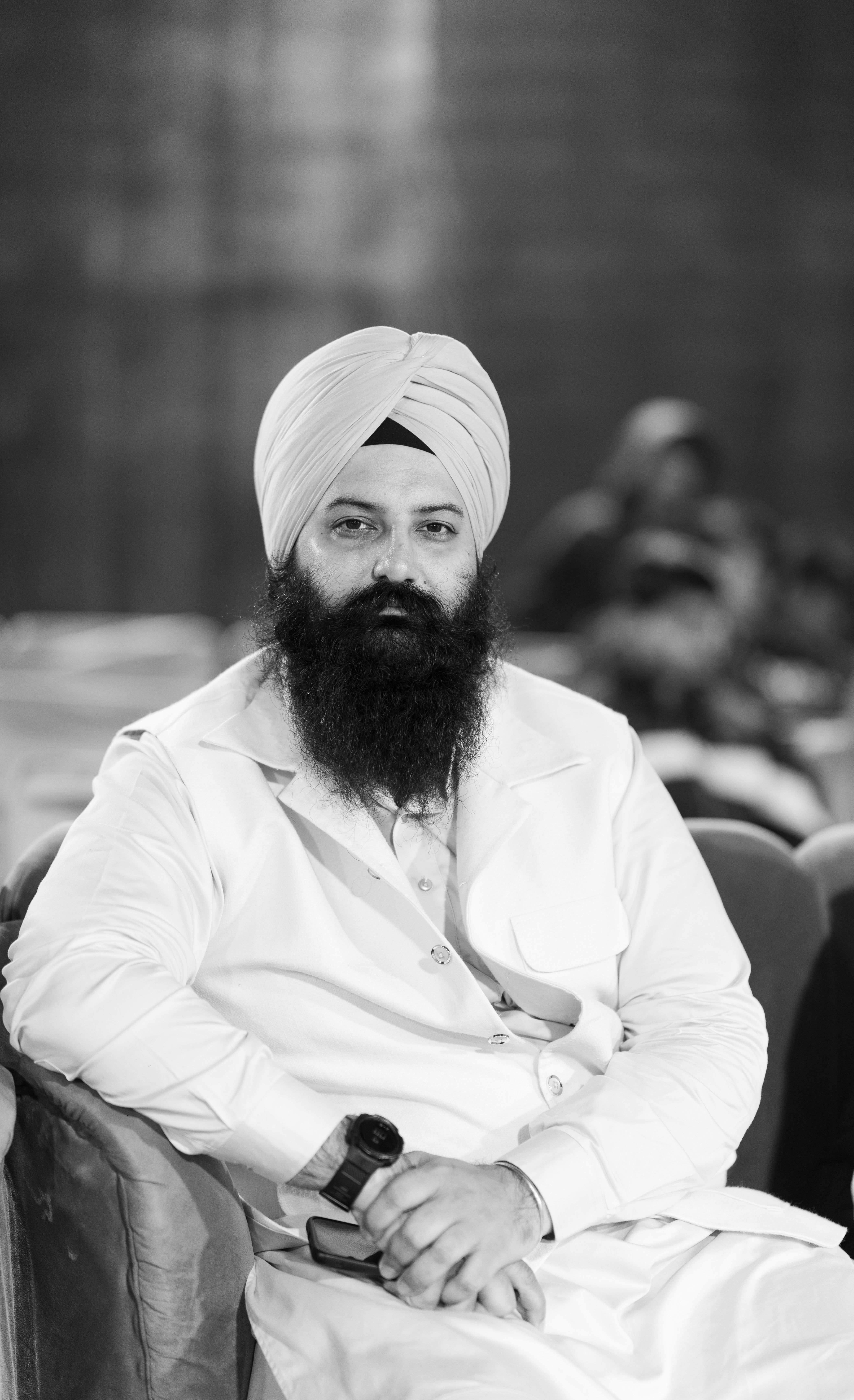 Monochrome portrait of a bearded man wearing a turban, seated indoors in formal attire.
