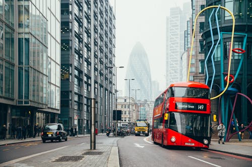 Free Double-deck Bus Parked Surrounded by Buildings Stock Photo