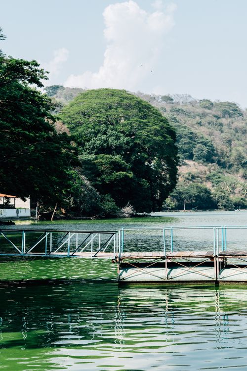 Free Scenic view of a lake with a dock and lush greenery, perfect for a peaceful retreat. Stock Photo
