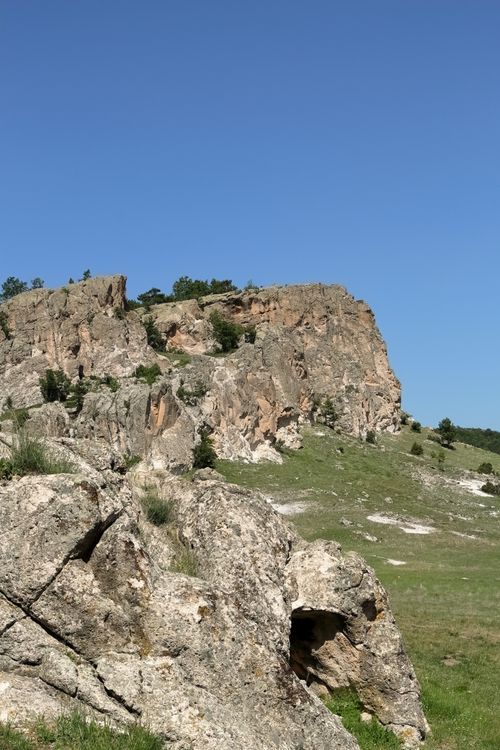 Free A stunning rocky cliff under a clear blue sky, showcasing natural beauty and rugged terrain. Stock Photo