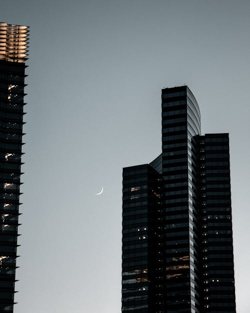 Modern skyscraper against night sky with moon