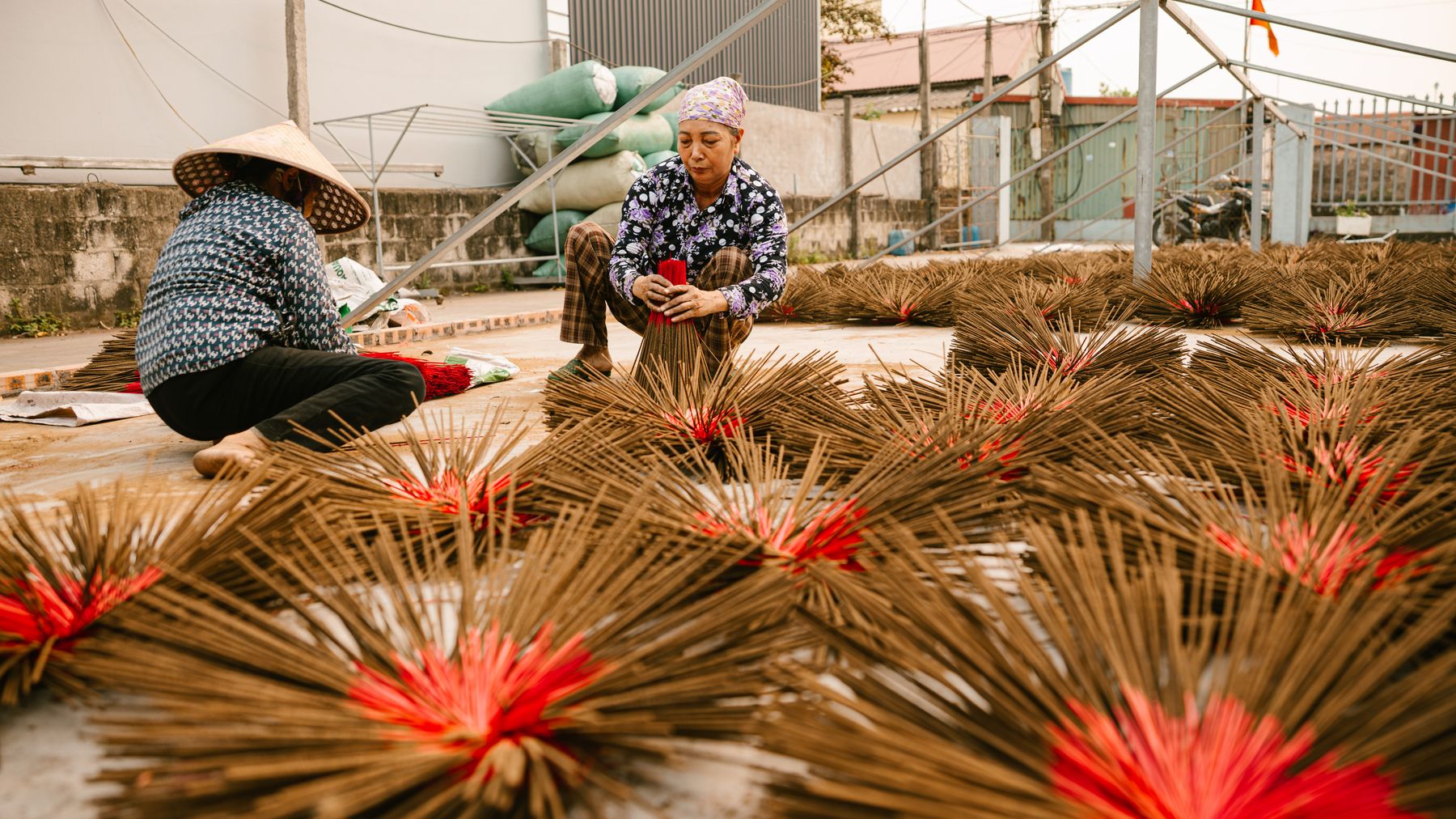 Handwerker fertigen im Freien Räucherstäbchen in einer vietnamesischen Werkstatt an.