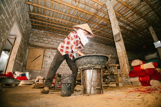 Worker in a rustic workshop making traditional incense with artisanal methods, showcasing cultural heritage.
