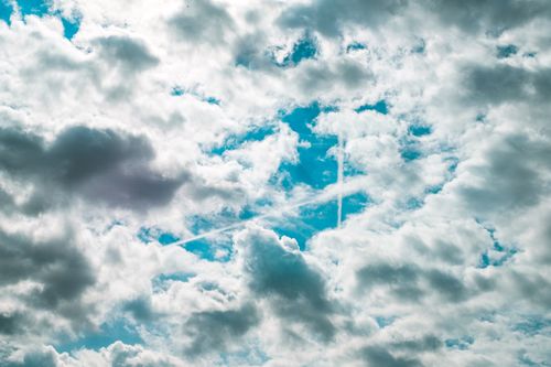 Free Vibrant and dramatic sky featuring thick clouds with blue sky peeking through. Stock Photo