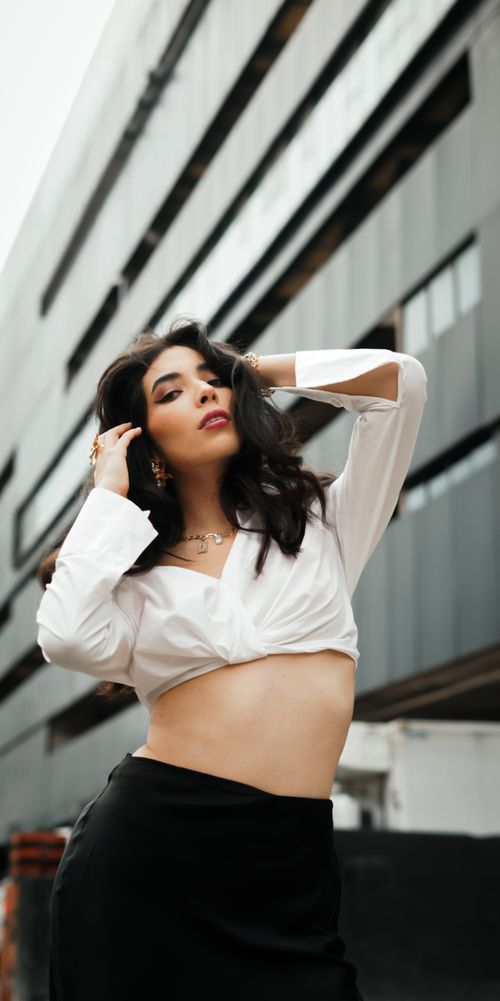 Free Confident young woman posing in modern urban setting, featuring trendy fashion style. Stock Photo