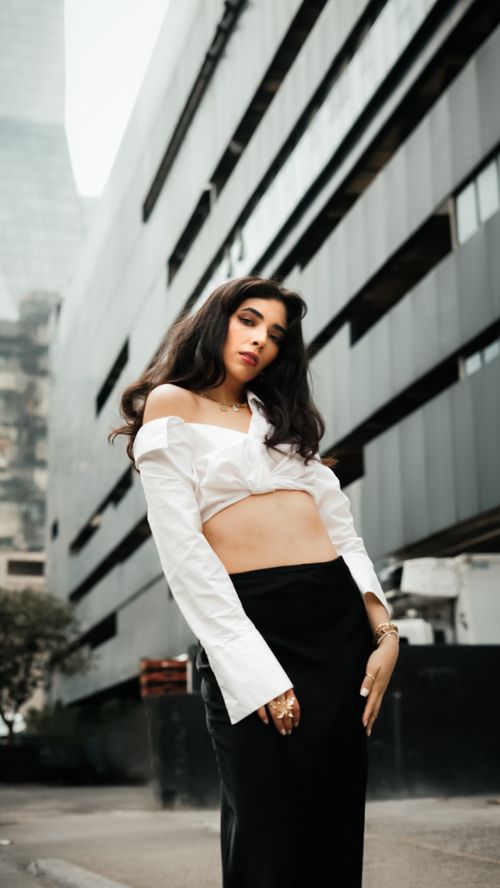 Free Stylish woman in a cityscape poses confidently against modern architecture. Chic and edgy fashion. Stock Photo
