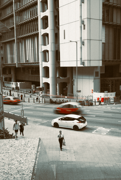 A bustling urban street on Hong Kong Island showcasing modern architecture and city life.